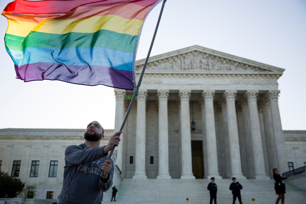 Same-sex marriage supporter Vin Testa, of Washington, DC, waves a rainbow pride flag near the Supreme Court, April 28, 2015 in Washington, DC.