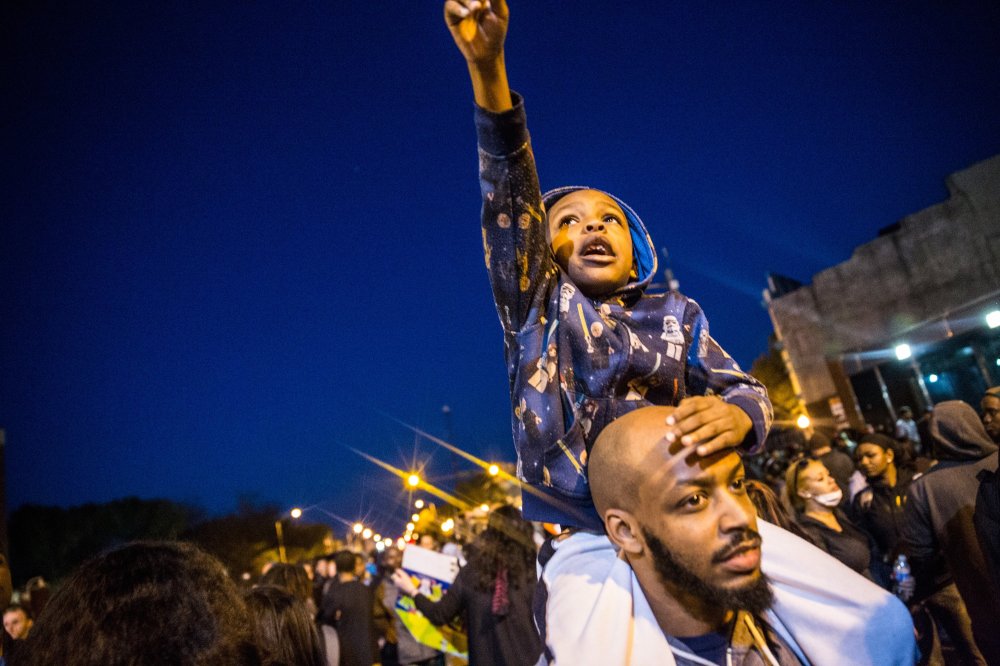 Protesters hang out front of riot police minutes before a mandatory, city-wide curfew of 10 p.m. near the CVS pharmacy that was set on fire yesterday during rioting after the funeral of Freddie Gray, on April 28, 2015 in Baltimore, Md.