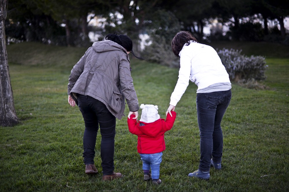 Same sex couple Olga Miranda (R) and Matilde Custodio (L) hold their daughter Carolina during a walk, February 23, 2014.