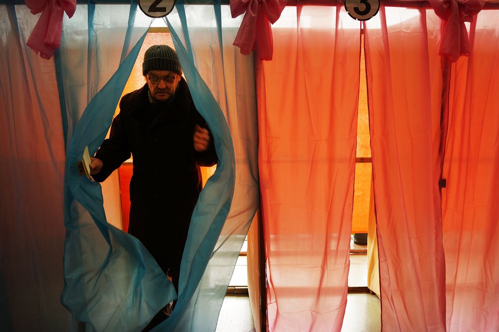 A man exits a polling booth with his ballot paper inside a polling station on March 16, 2014 in Perevevalne, Ukraine.