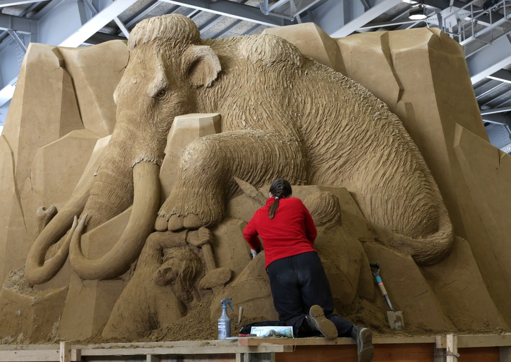 Karen Fralich of Canada finishes a sand sculpture at the Sand Museum in the Tottori Dune on April 3, 2014 in Tottori, Japan.