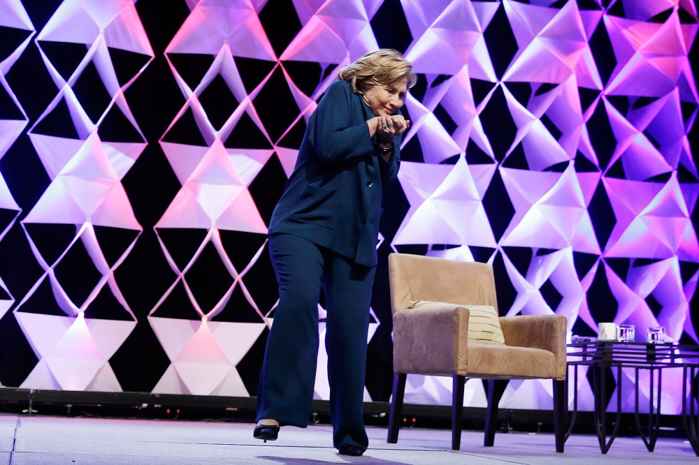 Former Secretary of State Hillary Clinton ducks after a woman threw an object toward her while she was delivering remarks in Las Vegas, April 10, 2014.