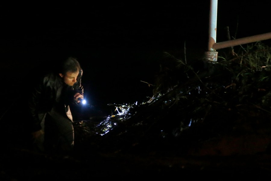 A rescuer looks into the debris along Short Creek looking for victims on September 15, 2015 in Hildale, Utah. (Photo by George Frey/Getty)