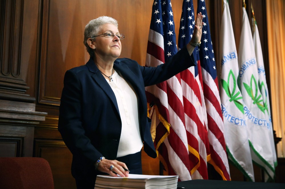 U.S. Environmental Protection Agency Administrator Gina McCarthy waves before signing new regulations for power plants at EPA headquarters June 2, 2014 in Washington, DC.
