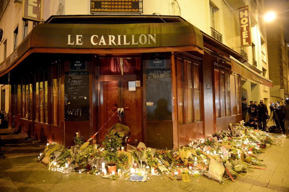 Flowers and candles are placed outside Le Carillon bar, the day after a deadly attack on Nov. 14, 2015 in Paris, France. (Photo by Antoine Antoniol/Getty)