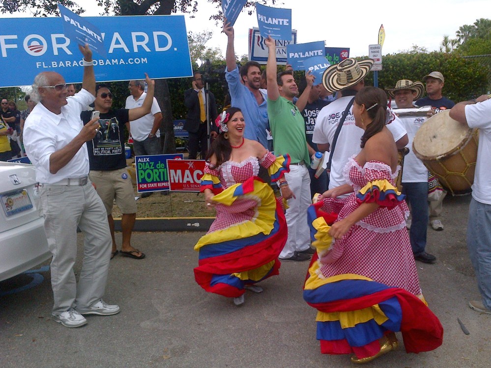Dancers perform as more than 250 people line up outside the Miami-Dade elections headquarters in Doral, Florida, on November 5, 2012 to cast absentee ballots in person, a day after a temporary shutdown at the site led to widespread confusion.   (Photo...