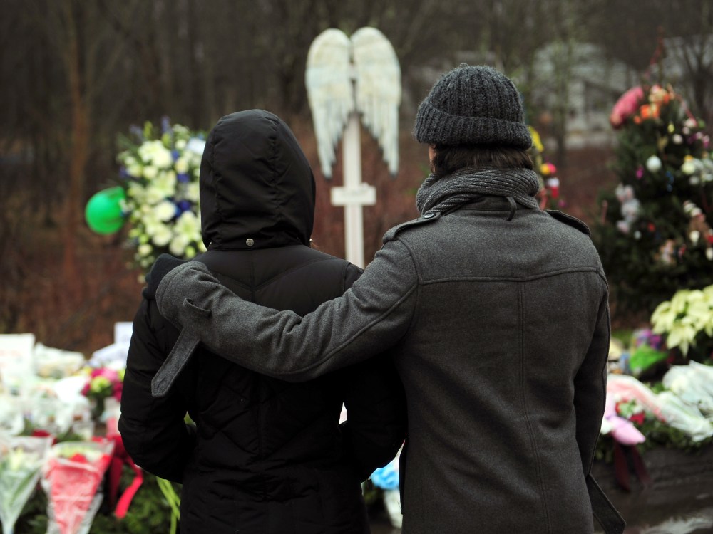 People pay their respects at a makeshift shrine to the victims of an elementary school shooting in Newtown, Connecticut, December 17, 2012. Funerals began Monday in the little Connecticut town of Newtown after the school massacre that took the lives of...