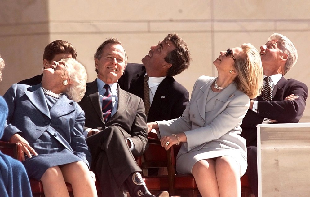 In less competitive times, George Bush, Barbara Bush and Jeb Bush, sit with First Lady Hillary Clinton and President Bill Clinton, watching US Army parachuters at the dedication of the George Bush Library in TX. (Photo by Joyce Naltchayan/AFP/Getty)