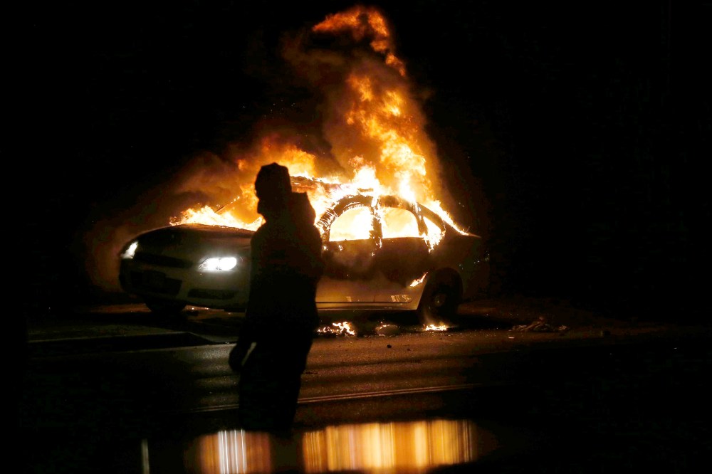 A car burns on the street after a grand jury returned no indictment in the shooting of Michael Brown in Ferguson, Mo. on Nov. 24, 2014. (Photo by Jim Young/Reuters)
