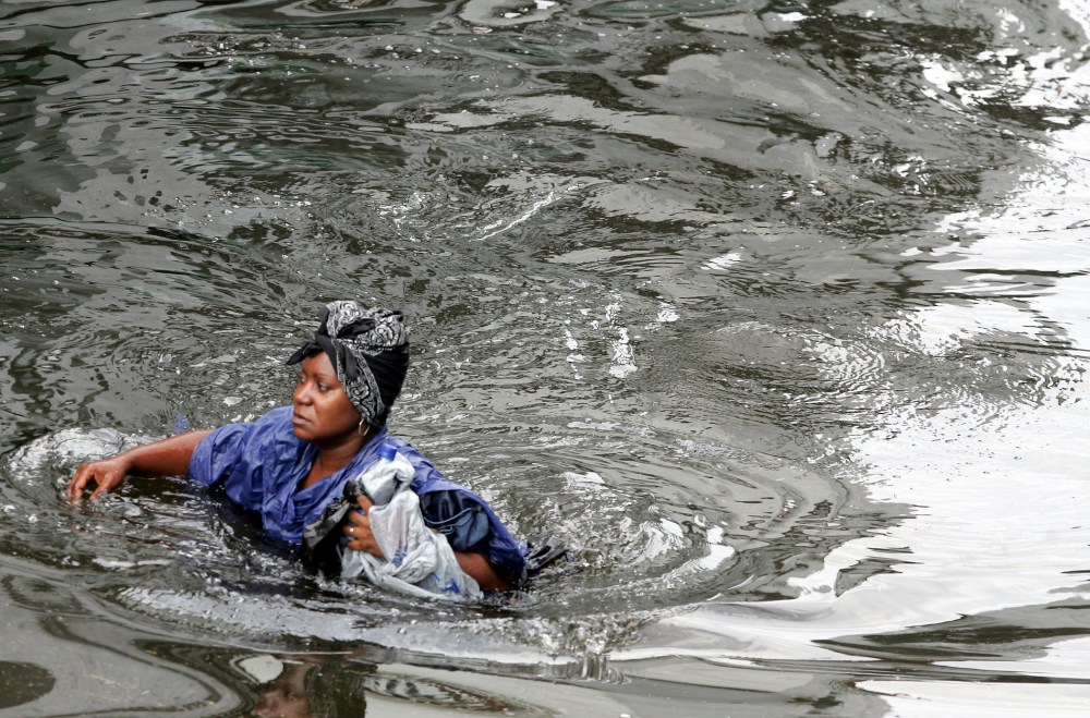 A woman walks through chest-deep floodwater from actual Hurricane Katrina in New Orleans, August 30, 2005.