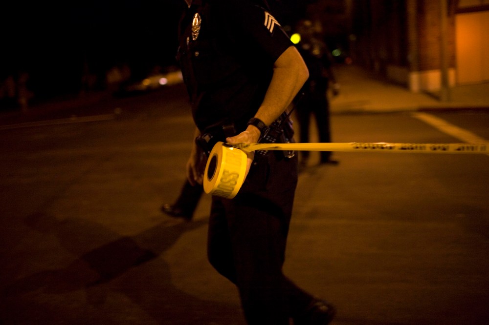 Los Angeles Police Department officers tape off a Crime Scene Investigation area.
