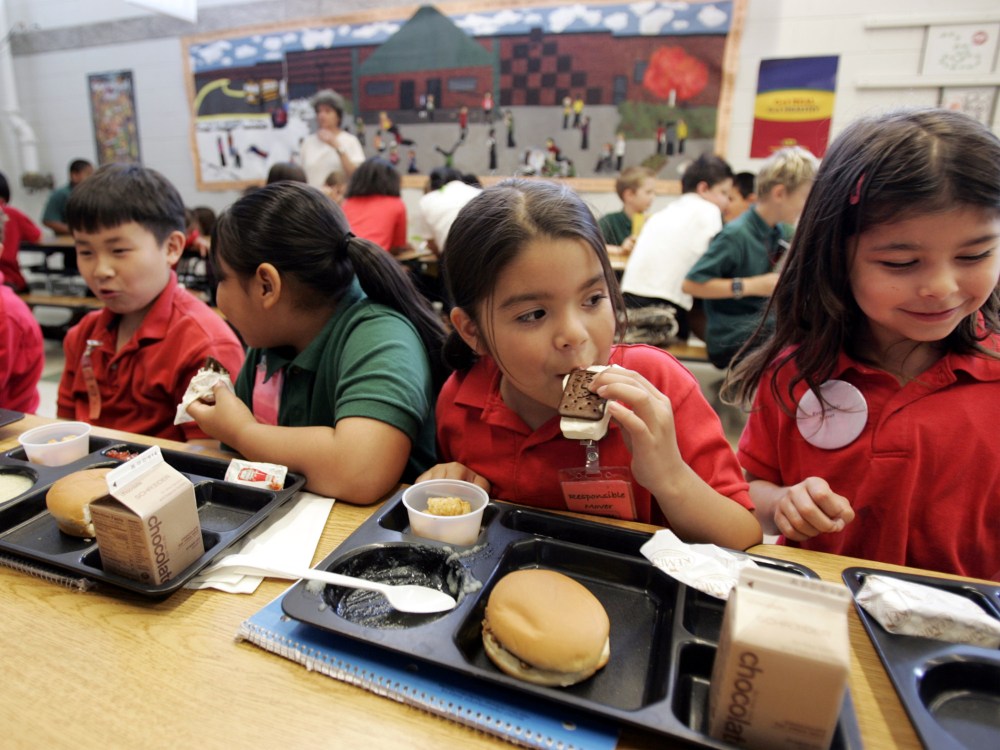 Elena Serrano, 7, second right, eats an ice cream sandwich during lunch at the Four Seasons Elementary School in St. Paul, Minn., June 29, 2006.