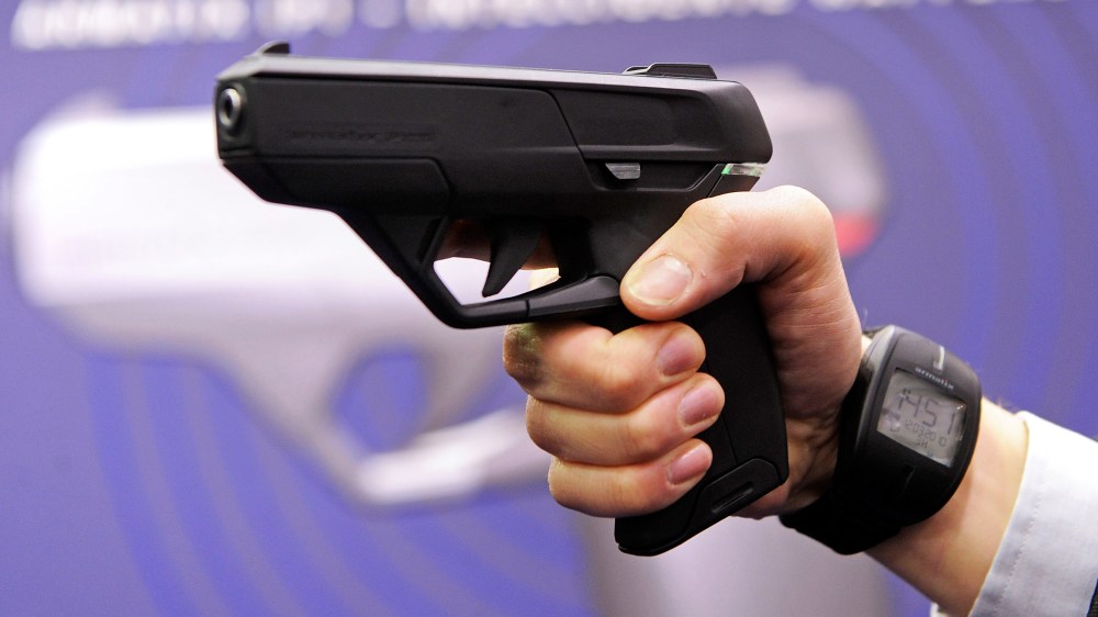 An employee of Armatix poses for photographers as he presents the "SmartGun Concept".