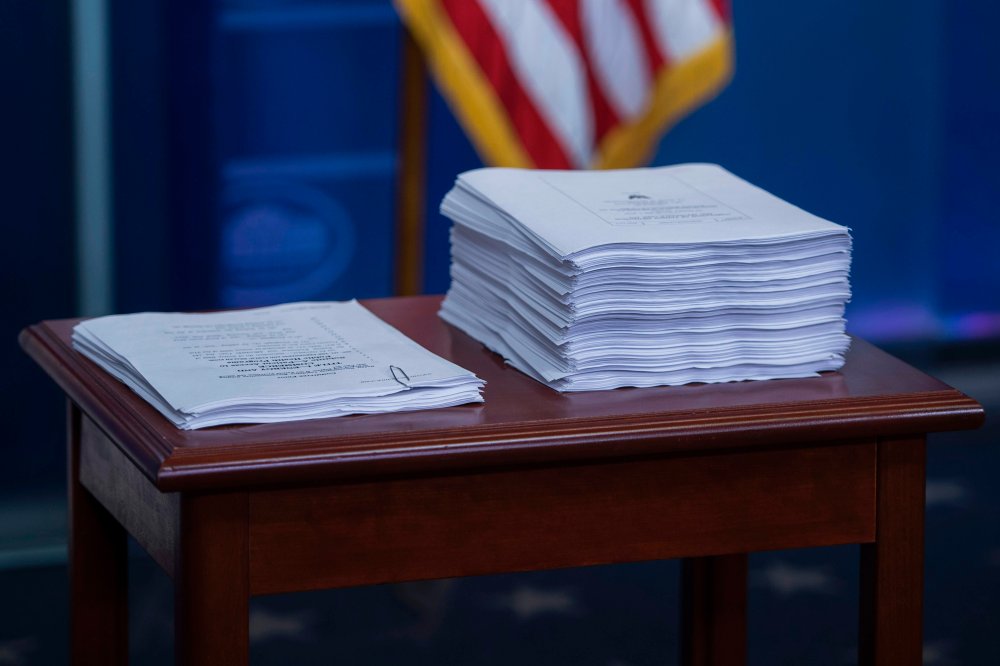 A print-out of the Affordable Care Act (ACA) (R) sits next to a copy of the plan introduced to repeal and replace the ACA during the daily briefing at the White House in Washington, DC on March 7, 2017.