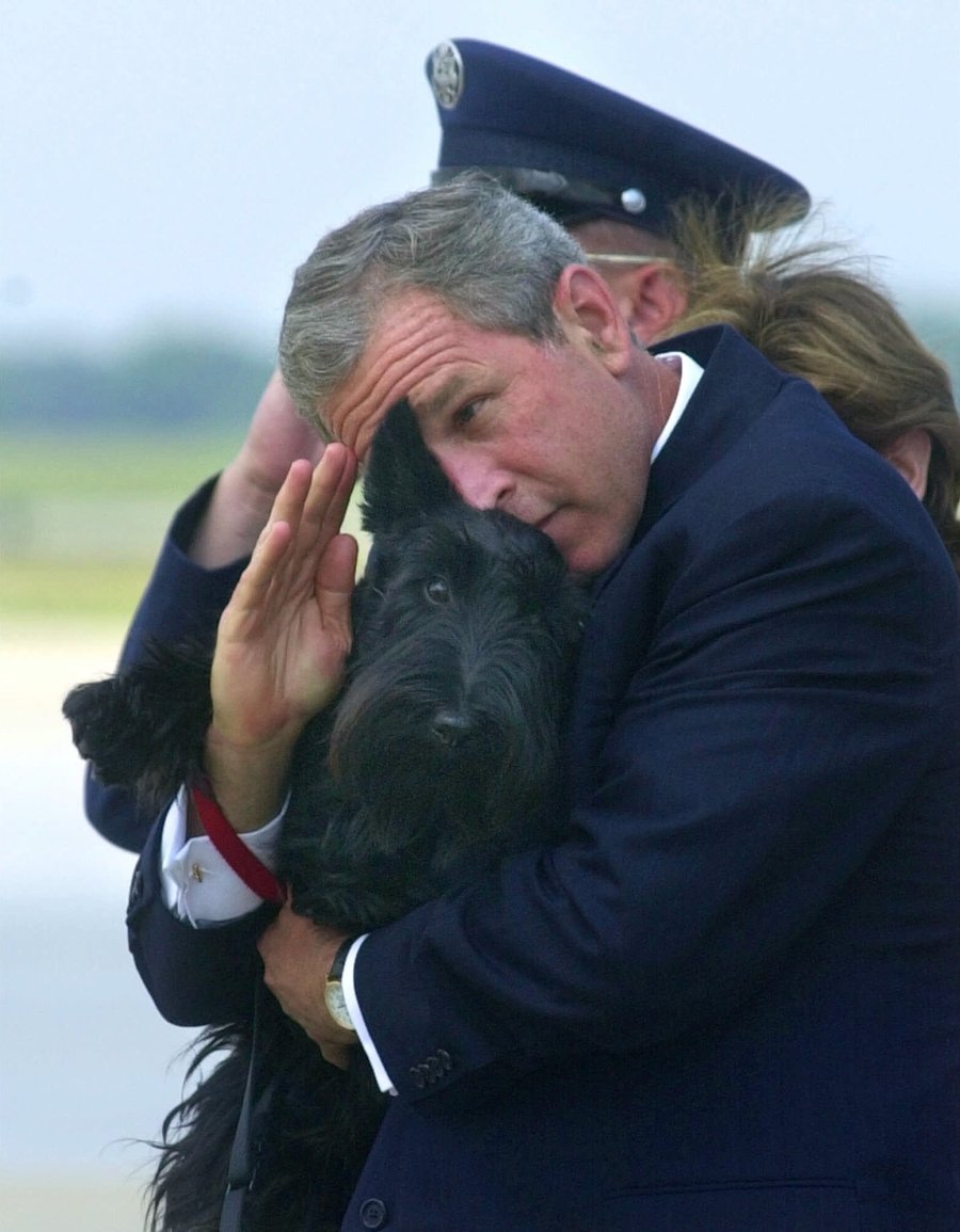President Bush does his best to salute while holding his dog Barney as they get off of Air Force One at Andrews Air Force Base, Md., Monday, June 25, 2001.