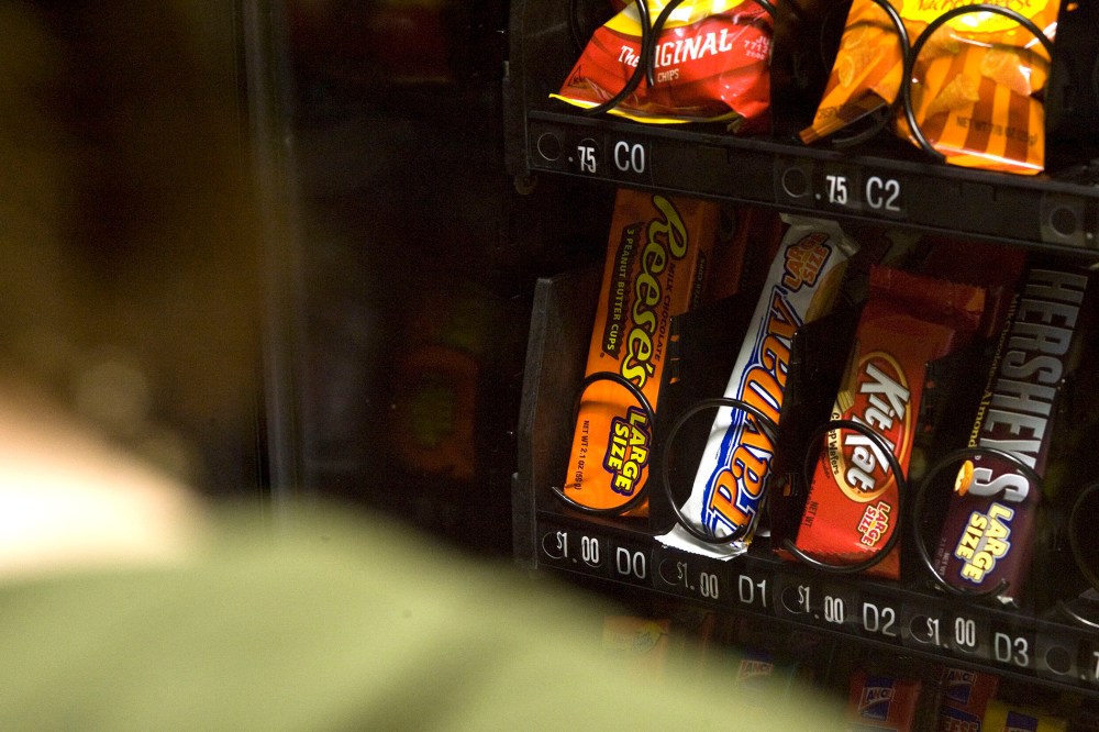 A stutdent stands in front of a vending machine in Charleston, W.Va.