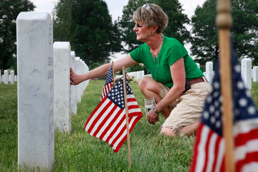 Anita Dixon, of Wichita, Kan., whose son Army Sgt. Evan Parker was killed while serving in Iraq in 2005, touches a grave in Arlington National Cemetery.