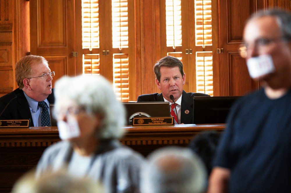 Brian Kemp, background right, Chairman of State Election Board, and David Worley, left, member of State Election Board, during a meeting to lay out the case of alleged voter registration fraud against the New Georgia Project at the Georgia State Capitol o