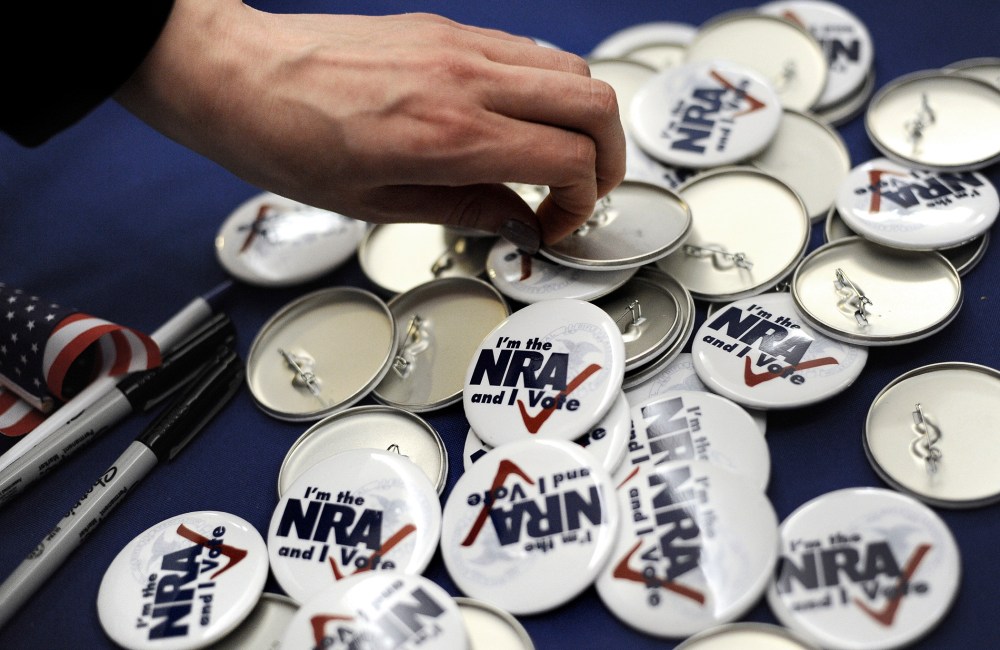 A woman grabs a button during a "lobby day" held by the National Rifle Association and other gun rights groups at the Legislative Office Building in Hartford, Conn., Monday, March 11, 2013.