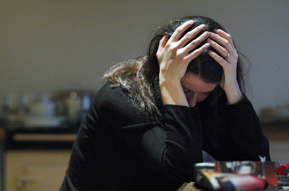 A posed woman with her head in her hands for a domestic violence awareness campaign. (Photo by David Cheskin/PA Wire/AP)