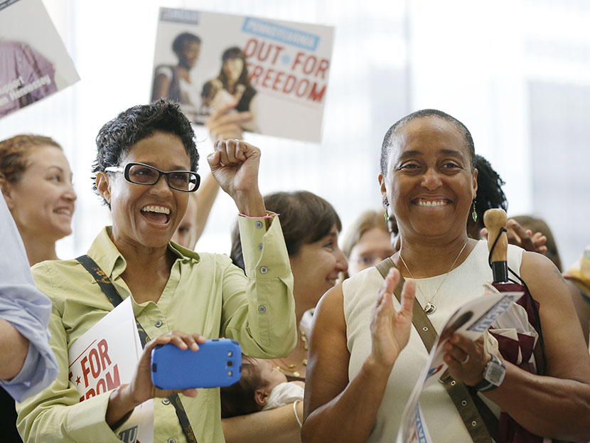 Gail Lloyd, left, and her partner of 17 years Angela Gillem react to an announcement by Pennsylvania Attorney Gen. Kathleen Kane during a news conference at the National Constitution Center, Thursday, July 11, 2013, in Philadelphia. (Photo by Matt...