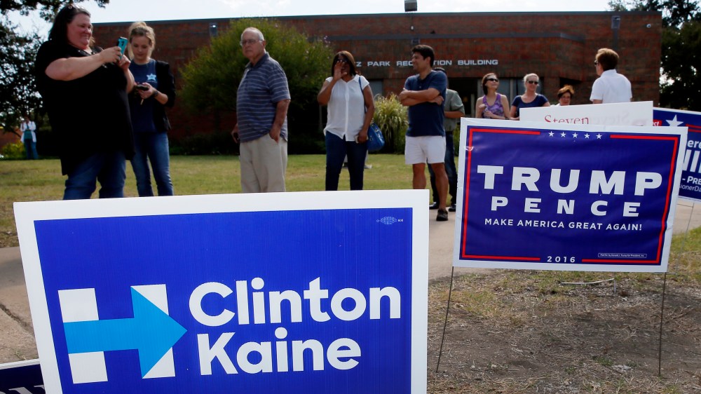 Early voters stand by campaign signs as they wait in line at a voting location in Dallas, Oct. 27, 2016. (Photo by Tony Gutierrez/AP)
