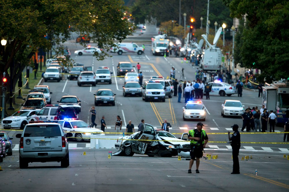 A damaged Capitol Hill police car is surrounded by crime scene tape on Constitution Avenue near the U.S. Capitol after a car chase and shooting Thursday, Oct. 3, 2013, in Washington.