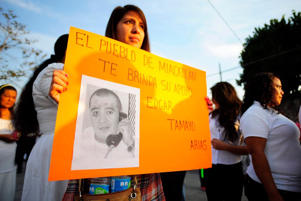 A woman holds up a sign that reads "The town of Miacatlan offers you our support, Edgar Tamayo Arias" during a protest demanding Tamayo's pardon, Jan. 19, 2014.