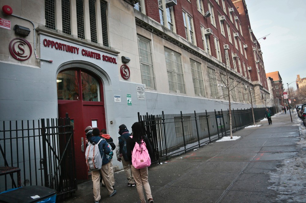 Students use the entrance for Success Academy and Opportunity Charity schools, both of which share space inside Harlem's P.S. 241, in New York on Dec. 20, 2013.