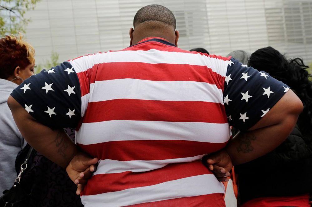 An overweight man wears a shirt patterned after the American flag during a visit to the World Trade Center, May 8, 2014 in New York. (Photo by Mark Lennihan/AP)