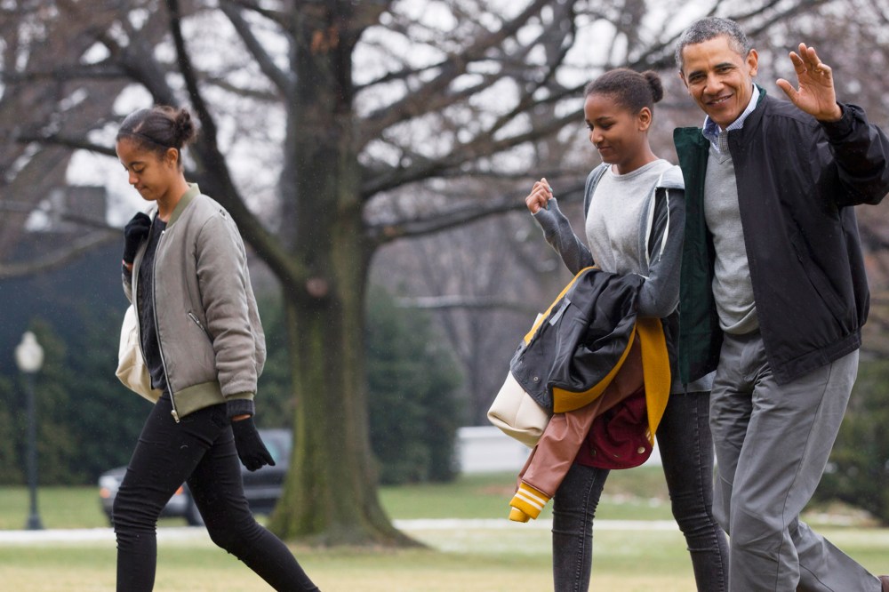 President Barack Obama, right, waves to the media with daughters Sasha and Malia, left, on Jan. 5, 2014. (Photo by Jacquelyn Martin/AP)