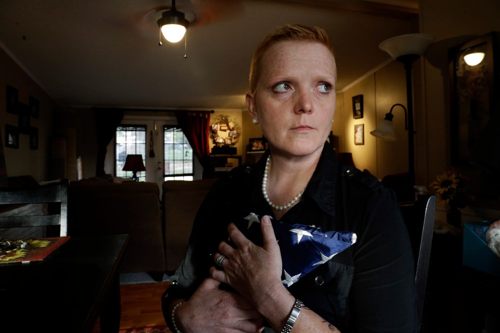 In this photo taken Wednesday, March 20, 2013 in Raeford, N.C., Tracy Dice Johnson holds a flag from a "widow's box" that platoon mates of her wife prepared during the service they had for their fallen comrade.