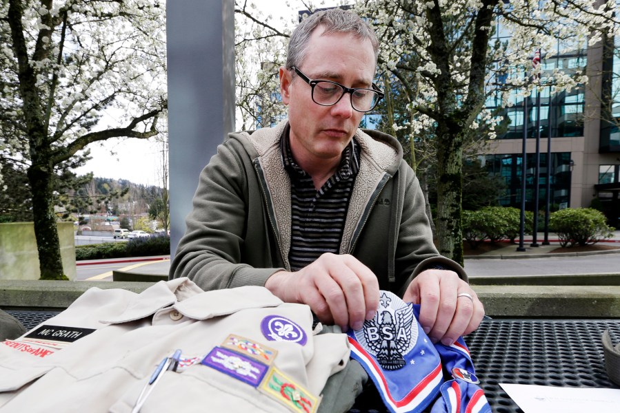 Geoff McGrath displays his Boy Scout scoutmaster uniform shirt and other scout items for the Seattle troop he led, April 1, 2014.