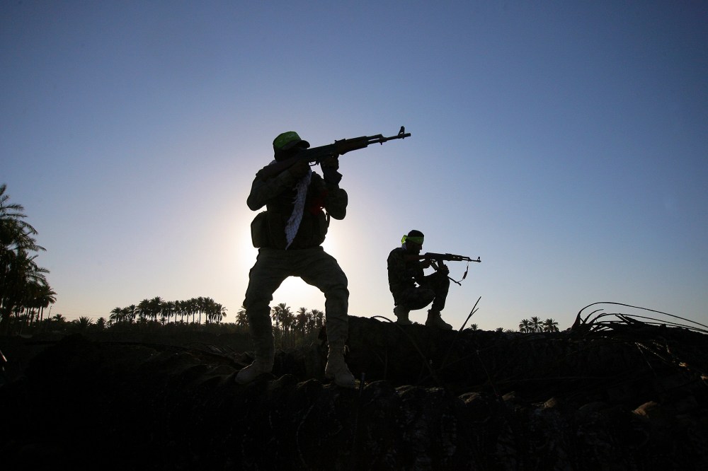 In this, Oct . 7, 2014 file photo, Iraqi Shiite militiamen aim their weapons during clashes with militants from the Islamic State group, in Jurf al-Sakhar, about 43 miles southwest of Baghdad, Iraq. (Photo by AP)