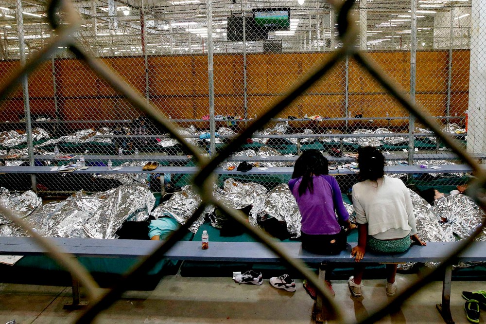 Two young girls watch a World Cup soccer match on a television from their holding area at the U.S. Customs and Border Protection Nogales Placement Center on June 18, 2014, in Nogales, Ariz. (Photo by Ross D. Franklin/AP)
