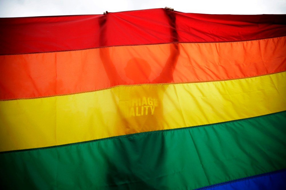 A man holds up a flag during a rally for gay marriage, June 26, 2013.
