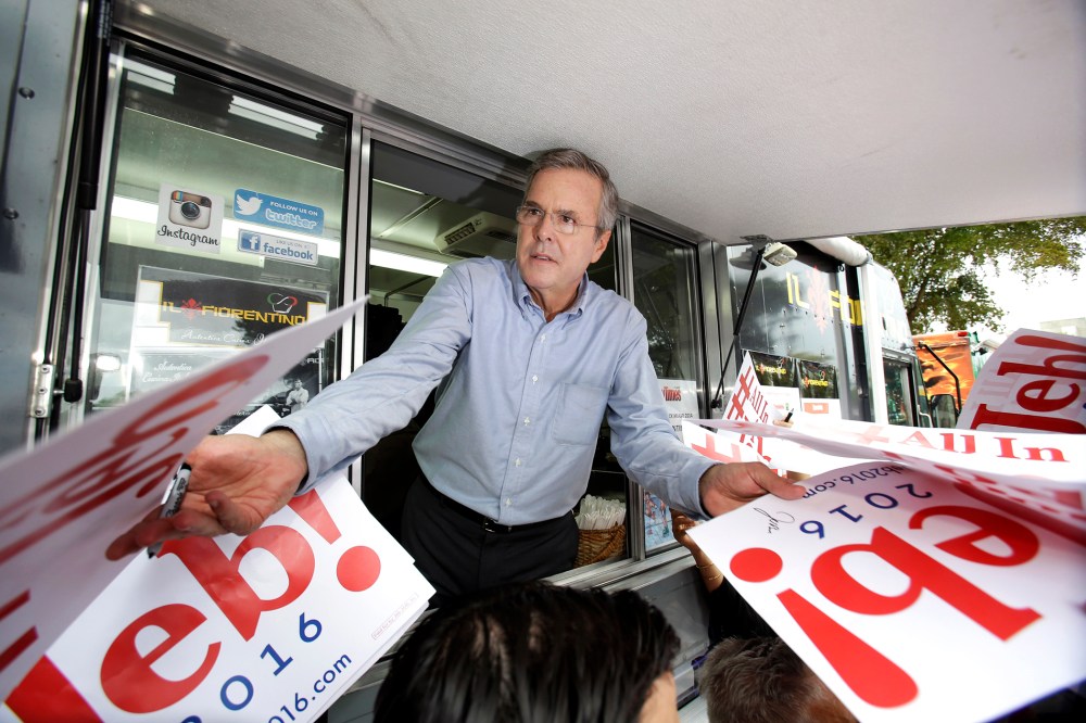 Former Florida Gov. Jeb Bush signs autographs from the window of a food truck after he formally announced that he would join the race for president with a speech at Miami Dade College, June 15, 2015, in Miami. (Photo by Wilfredo Lee/AP)