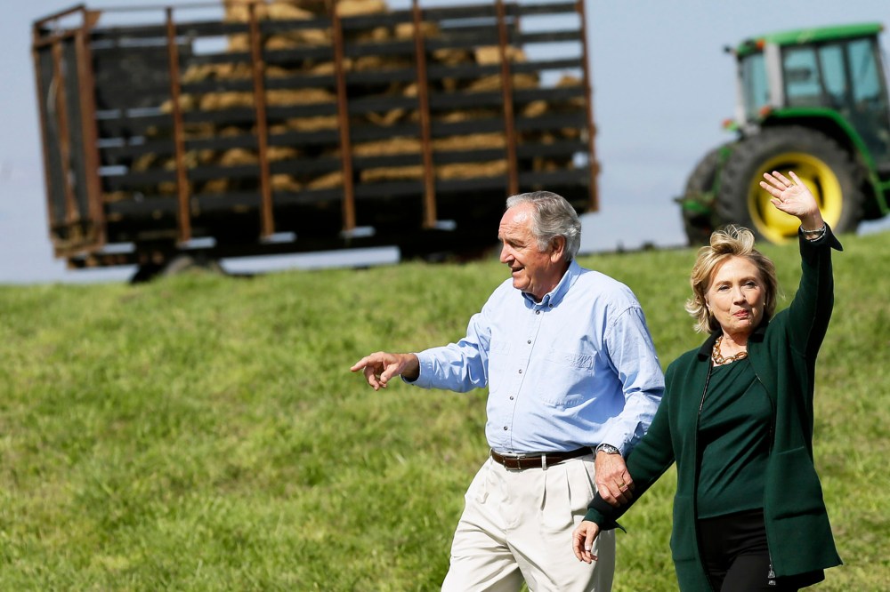 Former Secretary of State Hillary Rodham Clinton waves as she walks with U.S. Sen. Tom Harkin, left as they arrive at Harkin's annual fundraising Steak Fry, Sunday, Sept. 14, 2014, in Indianola, Iowa. (Photo by Charlie Neibergall/AP)