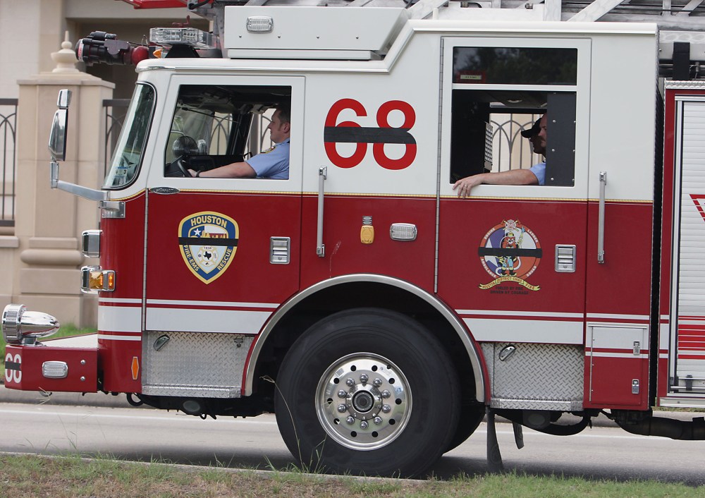 Houston Fire Department ladder truck 68 drives in a procession, June 2, 2013, in Houston. (Photo by James Nielen/Houston Chronicle/AP)