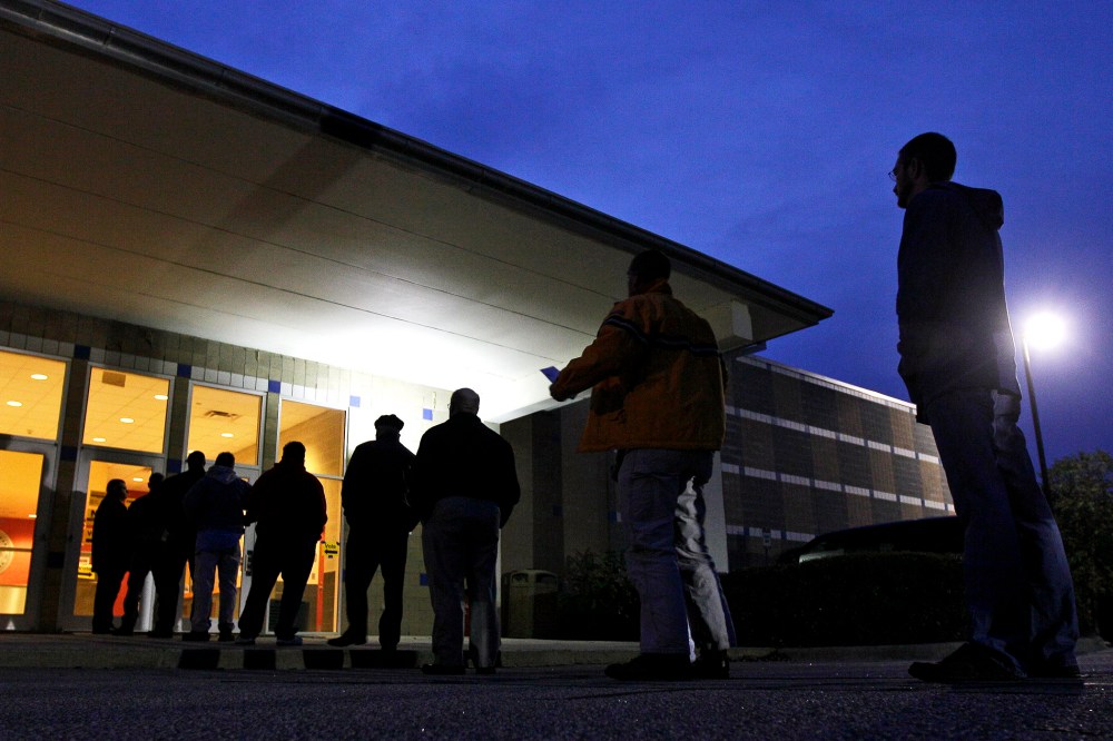 Voters stand in line before sunrise to cast their votes at a polling precinct in Apex, N.C.