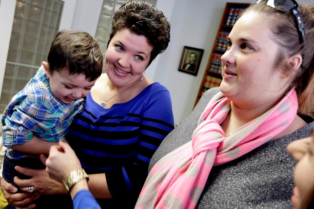 Nicole Yorksmith, left, holds her son while standing with her partner Pam Yorksmith, on Feb. 10, 2014, following a news conference in Cincinnati.
