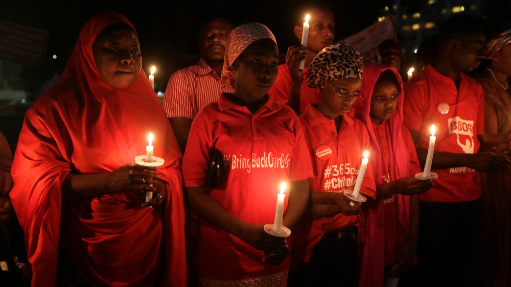People hold candles during a vigil to mark the one year anniversary of the abduction of girls studying at the Chibok government secondary school, Abuja, Nigeria, April 14, 2015. (Photo by Sunday Alamba/AP)