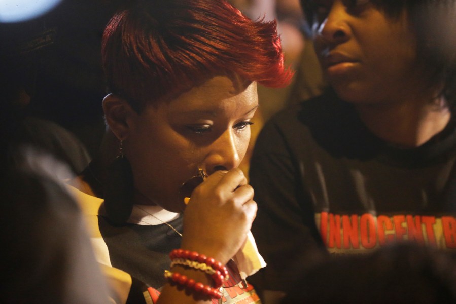 Lesley McSpadden, mother of Michael Brown, pauses during a rally in Ferguson, Mo. on Oct. 11, 2014 to look down at a memorial near her home and the place where her son was shot. (Photo by Charles Rex Arbogast/AP)