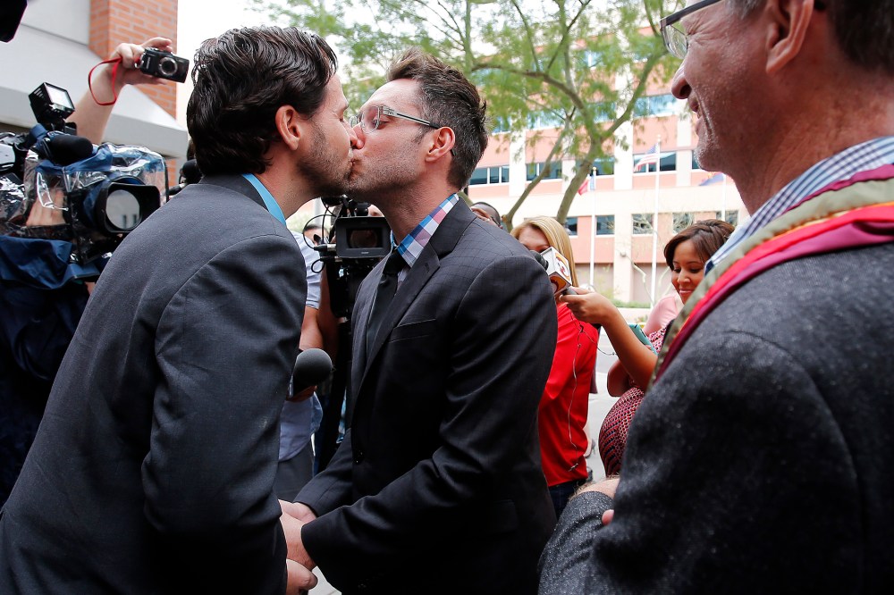 Kevin Patterson, left, and David Larance kiss after exchanging vows, as Rev. John Dorhaer, who performed the ceremony, stands at right, Oct. 17, 2014, in Phoenix, Ariz. (Photo by Rick Scuteri/AP)