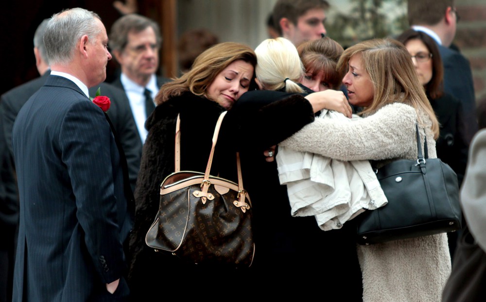 Family members of Missouri State Auditor Tom Schweich embrace outside The Church of St. Michael and St. George in Clayton, Mo., after his funeral on March 3, 2015. (Photo by Robert Cohen/St. Louis Post-Dispatch via AP)