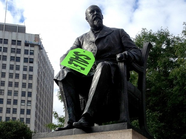 A neon green sale tag hangs on the statue of former Detroit mayor Hazen S. Pingree in Grand Circus Park in Detroit on Aug. 14, 2013. (Photo by Gary Miles/Detroit News/AP)
