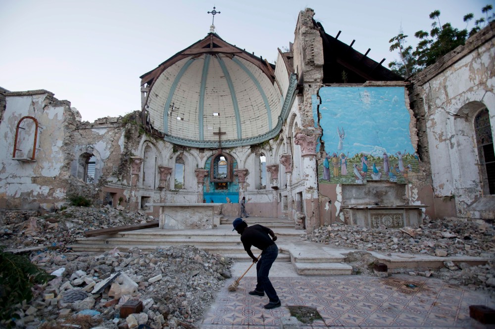 A man sweeps an exposed tiled area of the earthquake-damaged Santa Ana Catholic church, where he now lives, in Port-au-Prince, Haiti, Saturday, Jan. 12, 2013. Haitians recalled Saturday the tens of thousands of people who lost their lives in the...