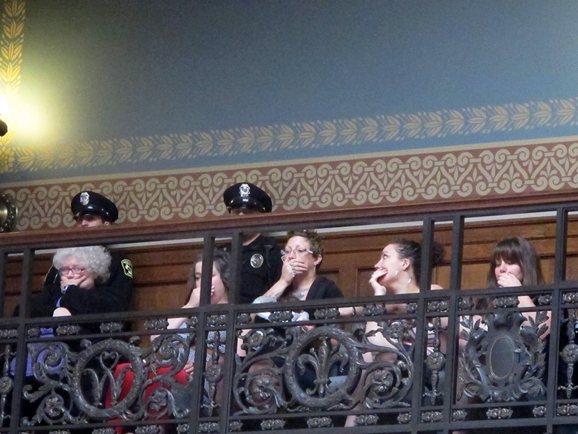 Opponents of a series of Republican-backed bills dealing with abortions hold their hands over their mouths while watching debate in the state Assembly on Thursday, June 13, 2013, in Madison, Wis.  (Photo by Scott Bauer/AP)