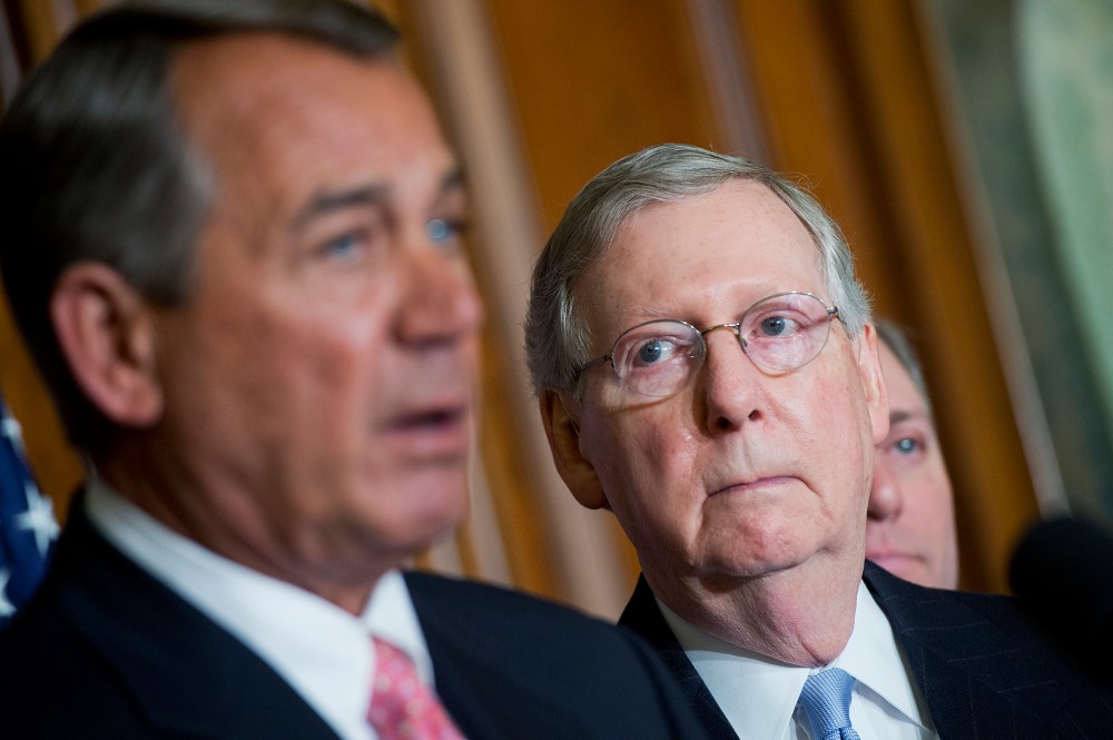 Senate Majority Leader Mitch McConnell looks on as Speaker John Boehner makes remarks during a signing ceremony in the Capitol's Rayburn Room for a bipartisan Medicare bill, April 16, 2015. (Photo By Tom Williams/CQ Roll Call/AP)