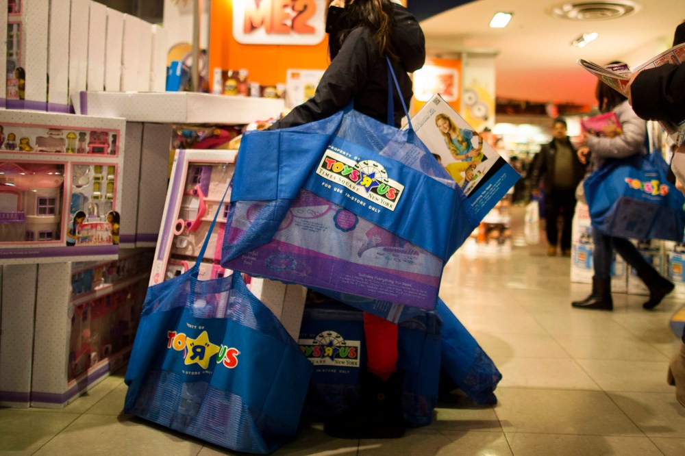 A shopper waits with her bags in the Times Square Toys R' Us on Nov. 28, 2013, Thanksgiving Day, in New York.